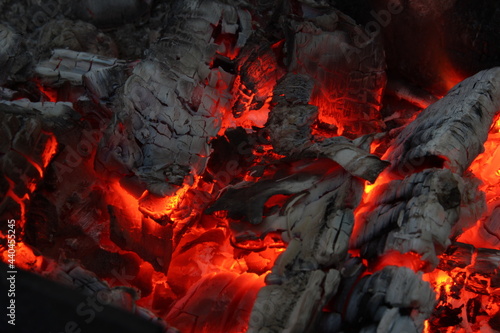 Smoldered logs burned in vivid fire close up. Atmospheric background with flame.