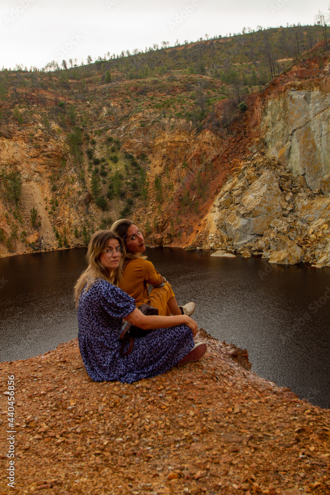 two young woman with dresses enjoying a break in a lake in Riotinto, huelva, Spain