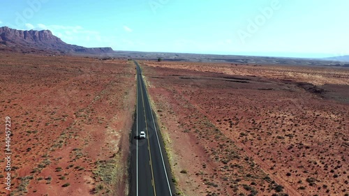 Car Driving At US Route 89 Between Brown Terrain In Arizona, USA. - aerial photo