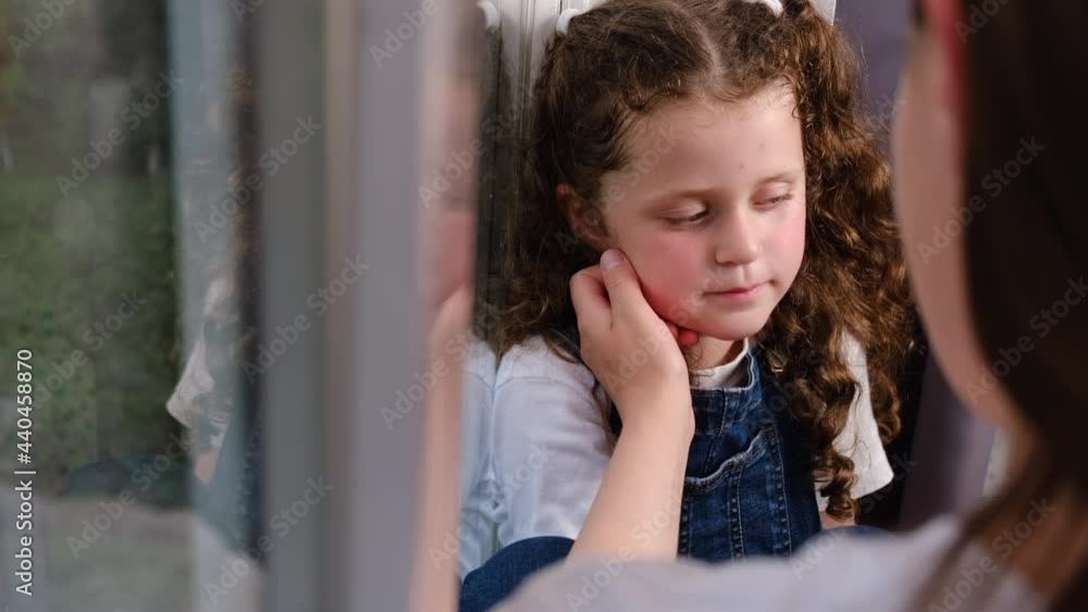 child psychologist concept. Side view of loving young mother touching upset little daughter face, expressing support, young mum comforting adorable preschool girl sit on sill, showing love and care child psychologist concept. Side view of loving young mother touching upset little daughter face, expressing support, young mum comforting adorable preschool girl sit on sill, showing love and care
