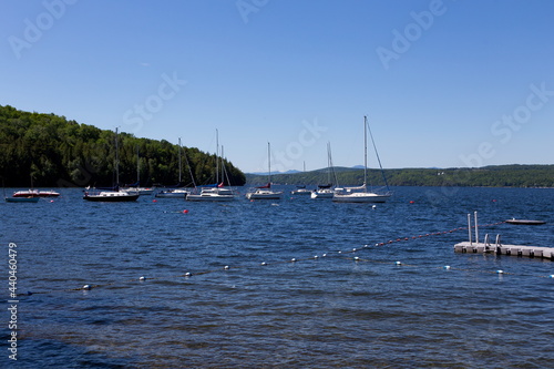 Sailboats moored on fresh water glacial Lake Memphremagog seen during a sunny summer morning, Georgeville, Eastern Townships, Quebec, Canada