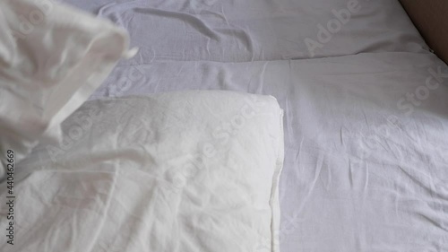The maid cleans the room. The woman changes the bed linen.