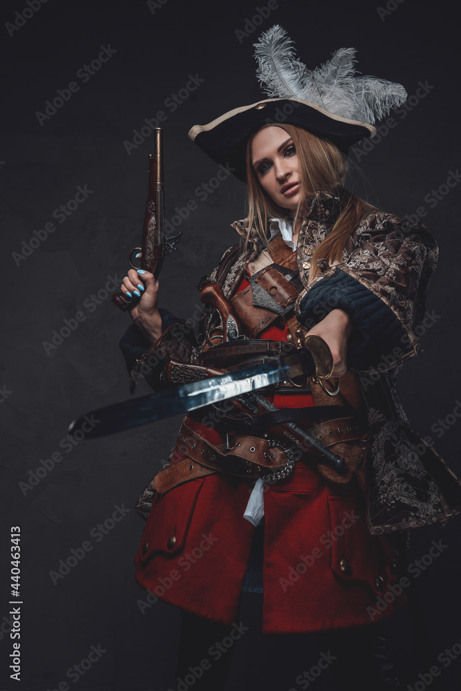 Fototapeta premium Elegant woman pirate with tricorn holding gun and saber