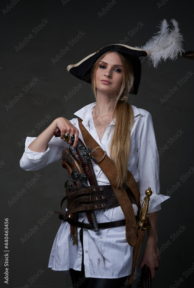 Fototapeta premium Elegant woman corsair posing with pistols indoors studio