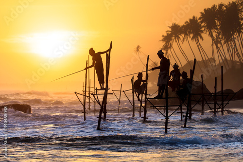 Stilt fishermen in silhouette sunset on the Koggala beach, Sri Lanka.