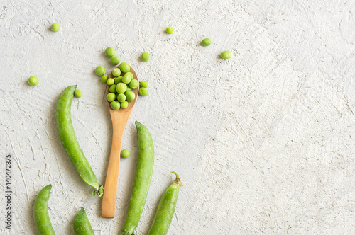 Fresh green peas with pod on white rustic  background, healthy green vegetable or legume ( pisum sativum )
