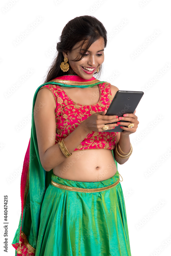 Young Indian traditional girl using a mobile phone or smartphone isolated on a white background Young Indian traditional girl using a mobile phone or smartphone isolated on a white background