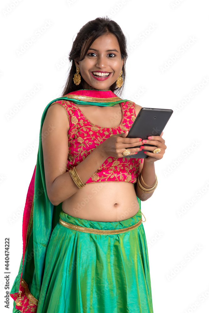 Young Indian traditional girl using a mobile phone or smartphone isolated on a white background Young Indian traditional girl using a mobile phone or smartphone isolated on a white background