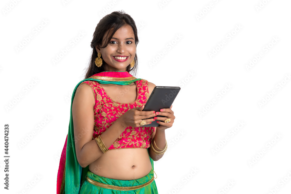 Young Indian traditional girl using a mobile phone or smartphone isolated on a white background Young Indian traditional girl using a mobile phone or smartphone isolated on a white background