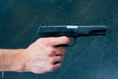 A man's hand holds a TT pistol.