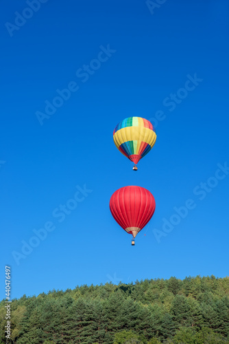 Multicoloured hot air balloon in the sky on a beautiful summer morning on the Balloon festival. © irina