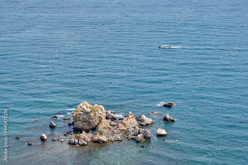 A pile of large rocky stones lying in the water. View from above.