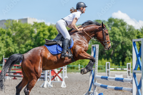 Young horse rider girl jumping on show jumping © skumer