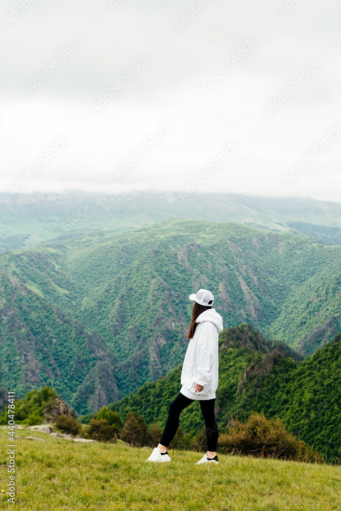 Stylish woman tourist admires the mountain landscape