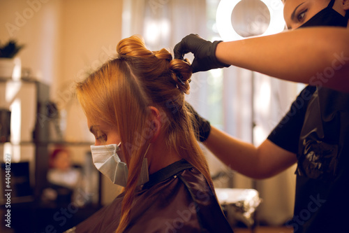 coloring hair, Hair dyeing. Young professional hairdresser applies hair dye to a female client.