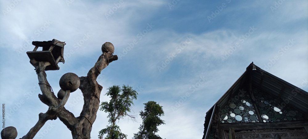 bird house on old wooden tree on cloudy blue sky