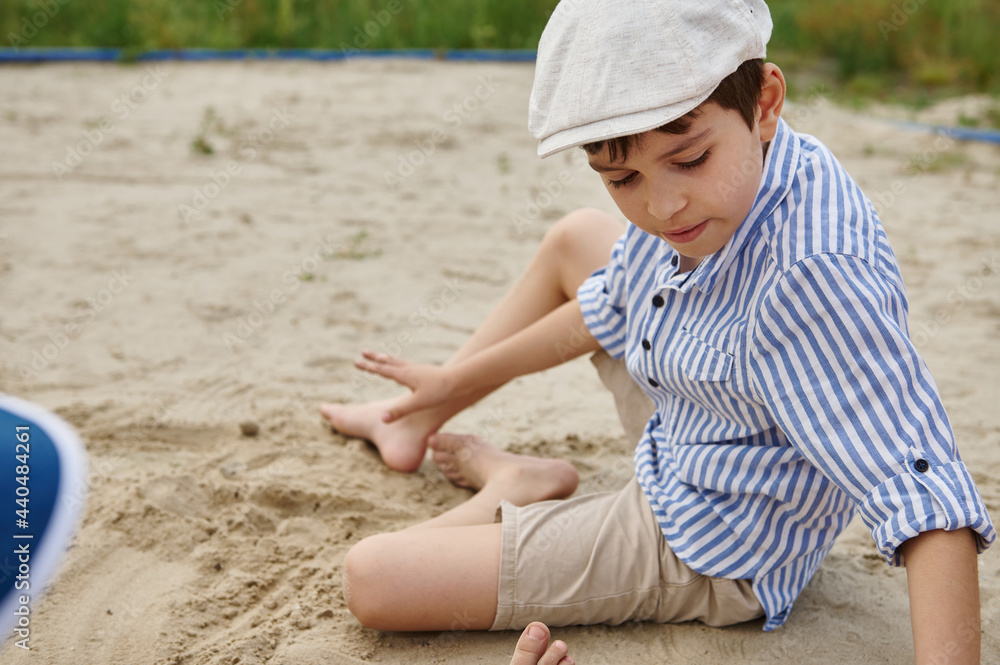 School boy playing on the sand. Outdoors summer holidays. Children summer camp School boy playing on the sand. Outdoors summer holidays. Children summer camp
