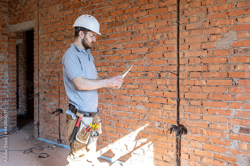 Wallpaper Mural An electrician contractor examines a blueprint at a construction site. Torontodigital.ca