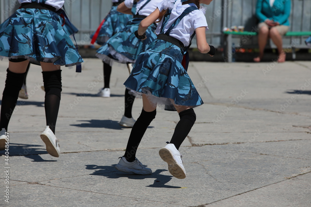 Children play sports and fitness outside.A group of girls jumps at a class in the schoolyard.Image of the physical development of students