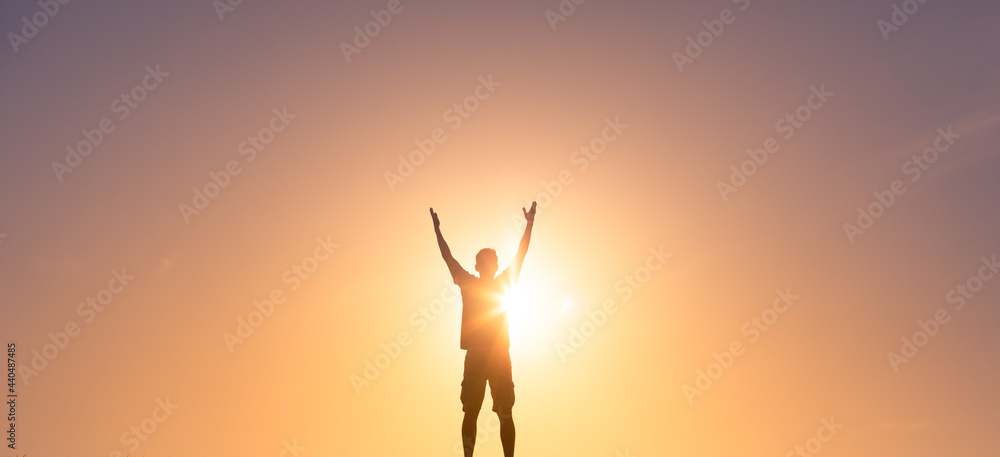 Young man lifting hands up to the sky feeling happy and free. 