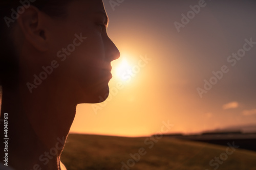 Life is beautiful in nature. Woman standing facing a beautiful golden sunrise. 