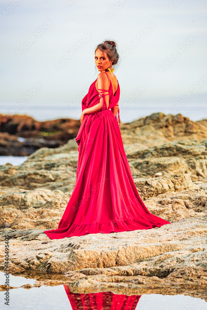 woman photoshoot in a long red dress on the beach