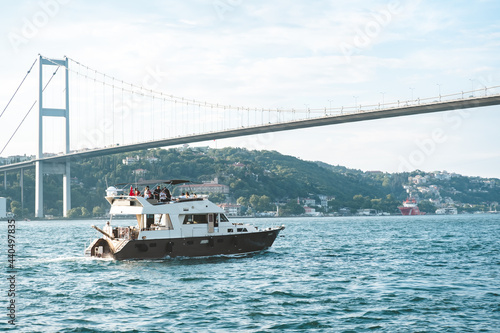 Istanbul, Turkey - June 2021: A ship passing through the Bosphorus. Boat tours in the Bosphorus. Touristic places to visit in Istanbul. Istanbul's historical places. Selective focus, close-up. © osmanozeroz