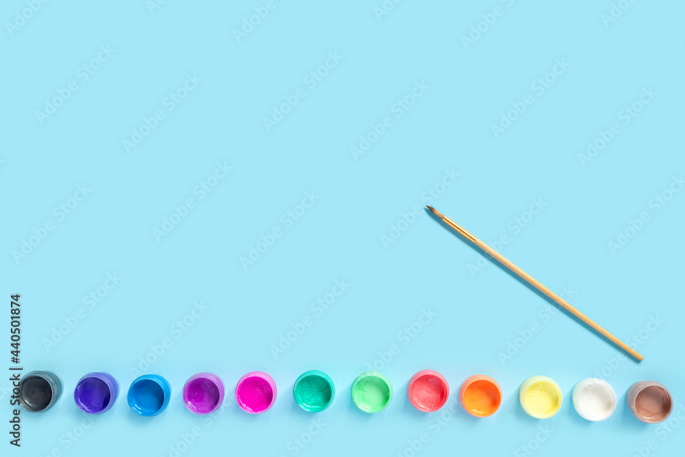 Paints and brushes for painting on blue paper background. Paints and brushes for painting on blue paper background.