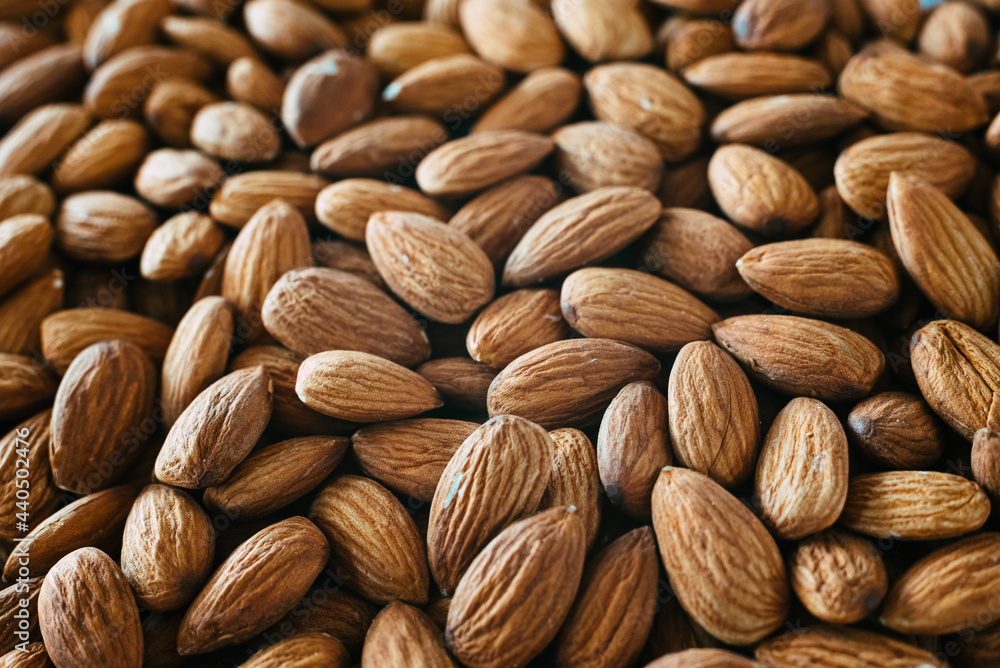 Fototapeta premium Close detail of a pile of raw almonds nuts with peel