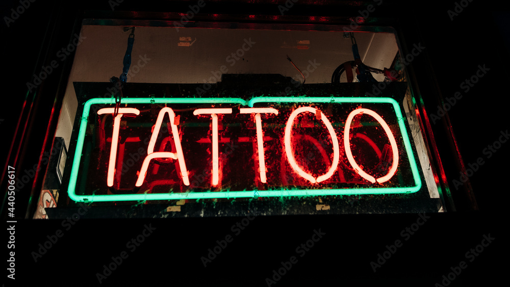 Red neon sign of the word Tattooist on a black background.