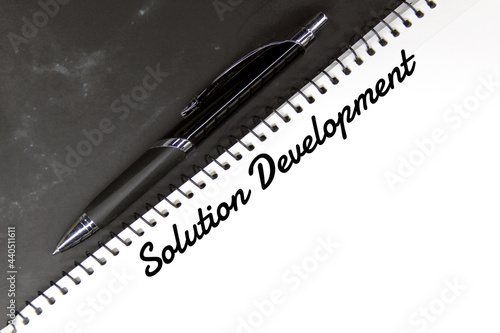 pen, white paper and the word solution development