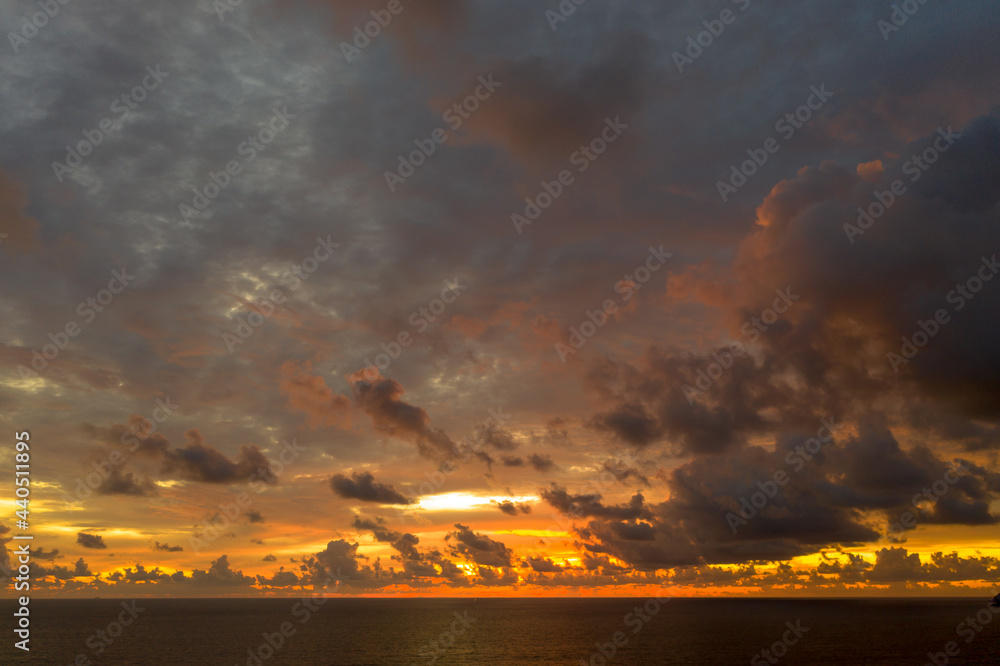 aerial view rain clouds Dark storm clouds over ocean open sea in evening sky sunset..stunning red sunset landscape Amazing light of nature cloudscape sky in twilight.