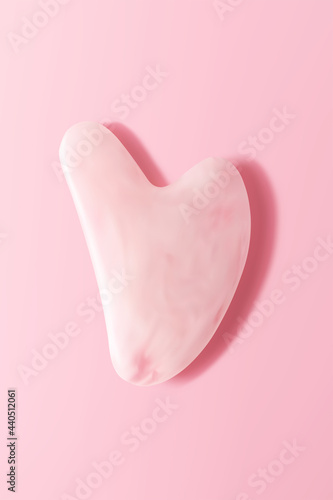 Pink quartz facial gua sha on pink background, top view. Trendy skincare facial massager tools, isolated 3d vector realistic illustration, vertical