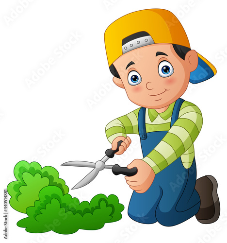 Young gardener trims a grass with scissors