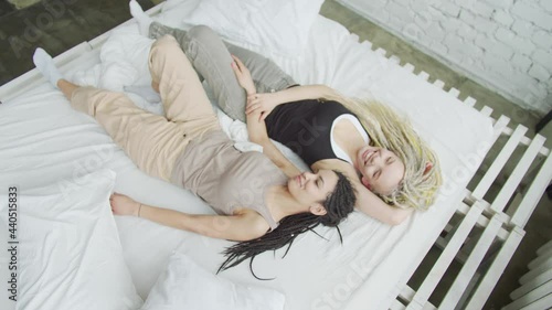 Young amorous couple lies thoughtfully in bed