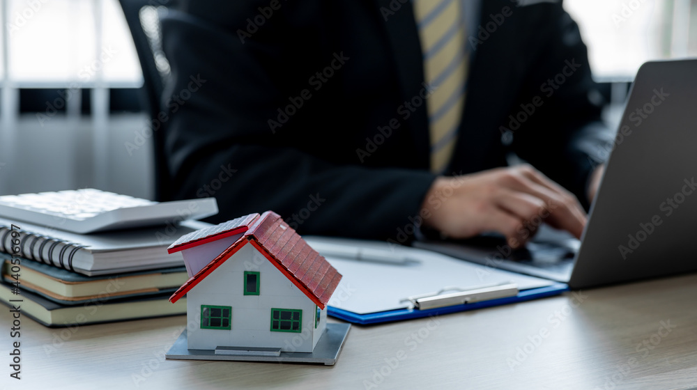 House model with real estate agent working at model office,Contracting home loans, home buying planning, business investment planning, business housing. House model with real estate agent working at model office,Contracting home loans, home buying planning, business investment planning, business housing.