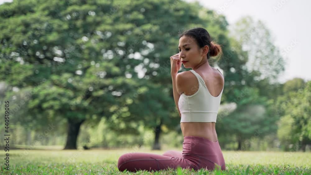 Asian young woman sitting on the grass in the HALF LORDS OF THE FISHES POSE outside in city park with the big trees background. Rearview of female practicing yoga outdoors on a sunny day.
Asian young woman sitting on the grass in the HALF LORDS OF THE FISHES POSE outside in city park with the big trees background. Rearview of female practicing yoga outdoors on a sunny day.