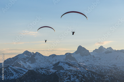 Paraglider duo flying over mountains photo