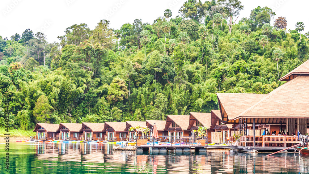 Naklejka premium Resort wooden home raft floating and mountain fog on river kwai at Khao Sok National Park, Surat Thani Province, Thailand. Concept image for transportation,boat,nature,scenery,travel,outdoor
