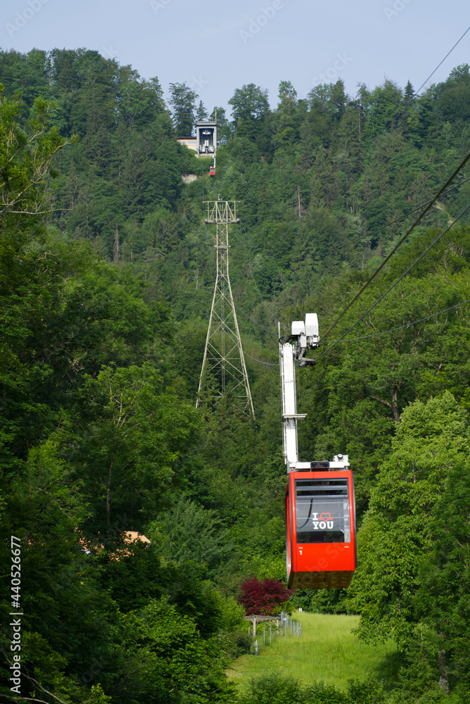 Fototapeta premium Red cable car at sunny summer day morning arriving at station. Photo taken June 18th, 2021, Zurich, Switzerland.