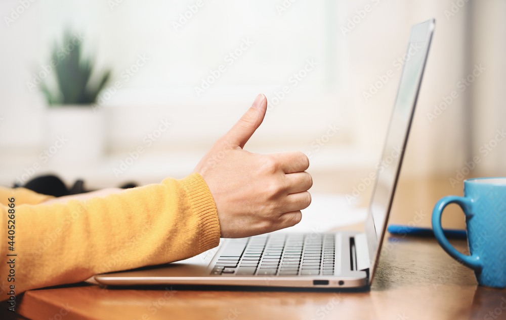 Side view of slim laptop and like thumb up hand. Distant learning. working from home, home office or online courses e-learning. vlogger blogger streaming. Happy client Side view of slim laptop and like thumb up hand. Distant learning. working from home, home office or online courses e-learning. vlogger blogger streaming. Happy client