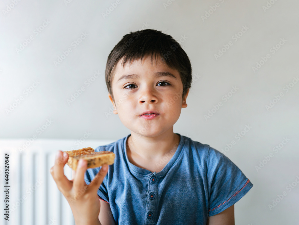 Portrait healthy Child boy eating honey on toasted for his breakfast before go to school, Happy kid child eating butter on bread in the morning, Healthy food for children concept Portrait healthy Child boy eating honey on toasted for his breakfast before go to school, Happy kid child eating butter on bread in the morning, Healthy food for children concept
