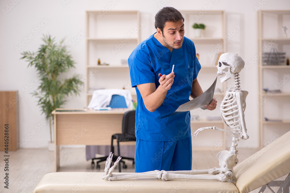 Young male doctor and skeleton patient in antismoking concept