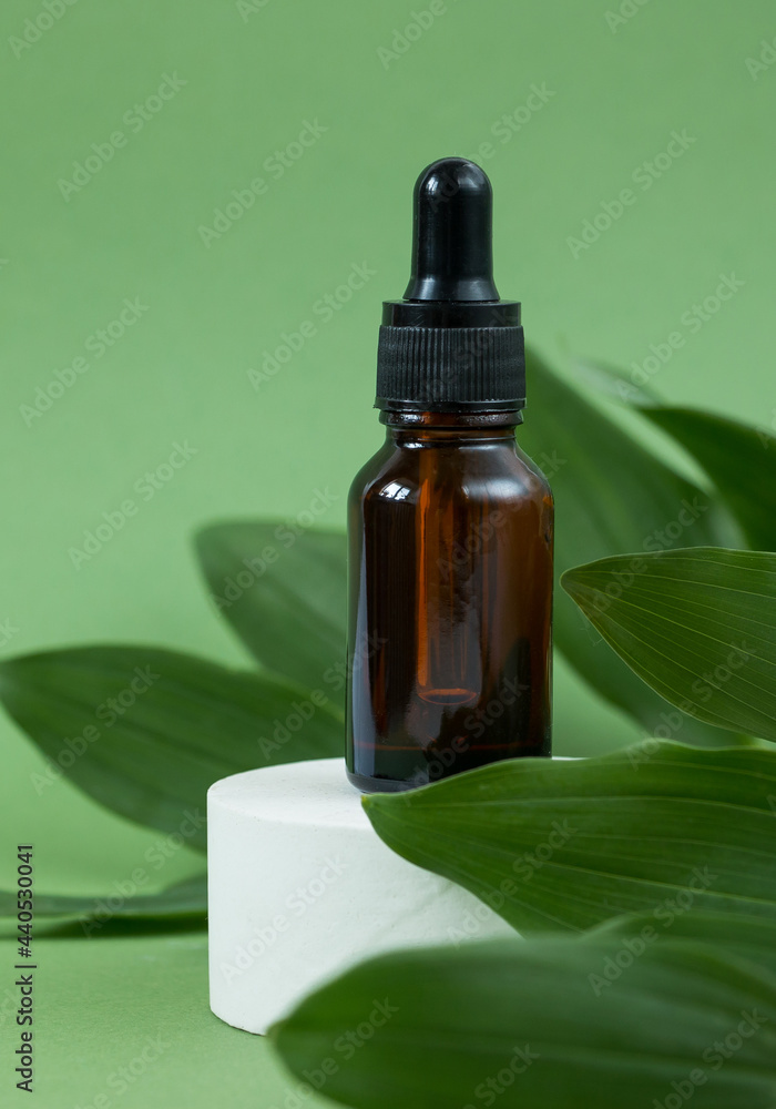 Amber glass cosmetic bottles, concrete podium on a green background. Natural organic beauty product concept. Spa, skin care, body care Amber glass cosmetic bottles, concrete podium on a green background. Natural organic beauty product concept. Spa, skin care, body care