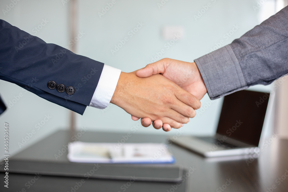 close up Business people shaking hands and smiling their agreement to sign contract and finishing up a meeting
