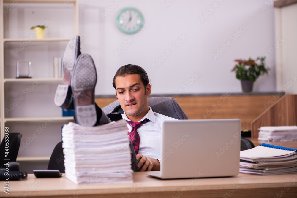 Young male employee extremely tired with excessive work Young male employee extremely tired with excessive work