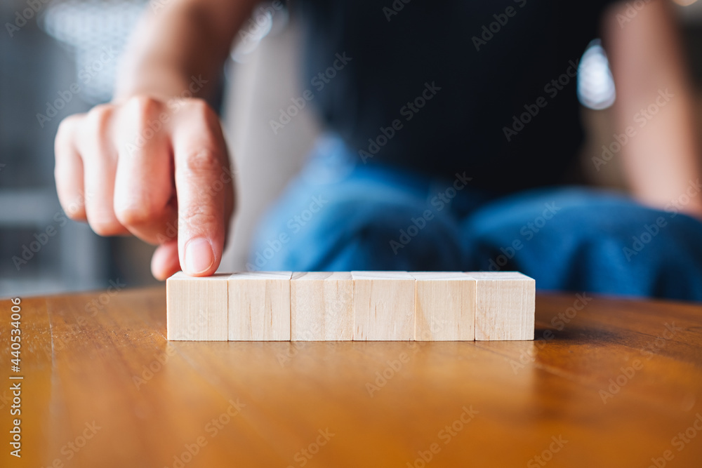 Closeup image of a hand choosing and picking six pieces of blank wooden cube block Closeup image of a hand choosing and picking six pieces of blank wooden cube block
