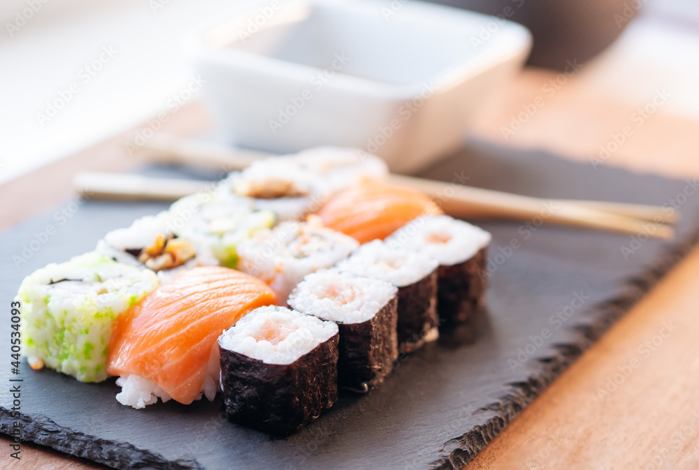 Close-up of a plate of sushi and chopsticks. Selective focus Close-up of a plate of sushi and chopsticks. Selective focus