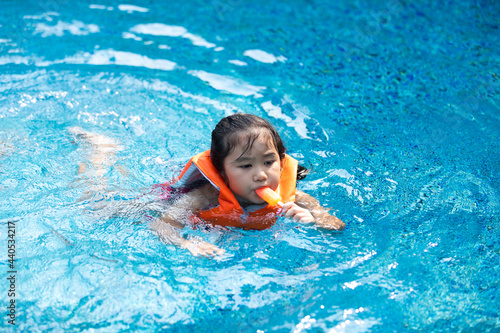 Happy Asian family vacation. Young Asian father with son and daughter enjoy by swimming pool at the hotel. Happy family summer vacation concept.