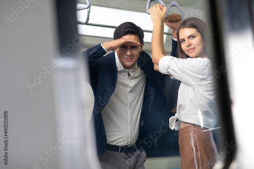 Man and woman couple passengers talking on Urban Public Transport Metro. Business people go to work by public transport